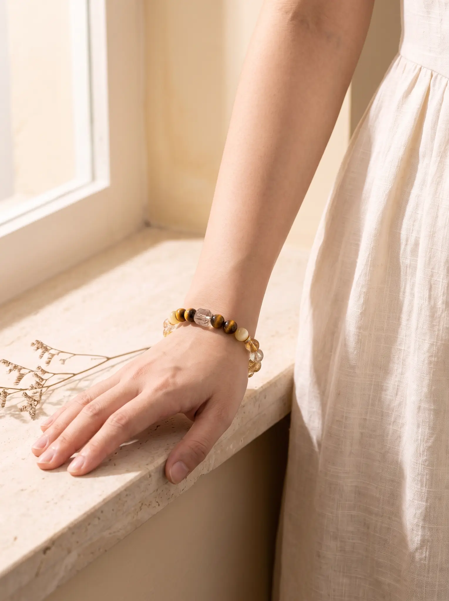 JIN bracelet worn on a sunlit marble window sill