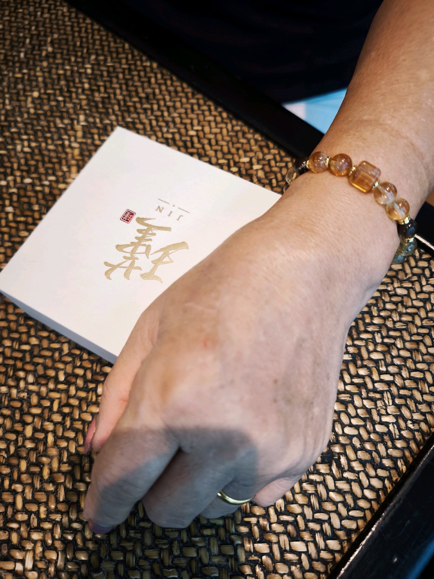 Irene Goh wearing The Strategist bracelet beside JIN packaging